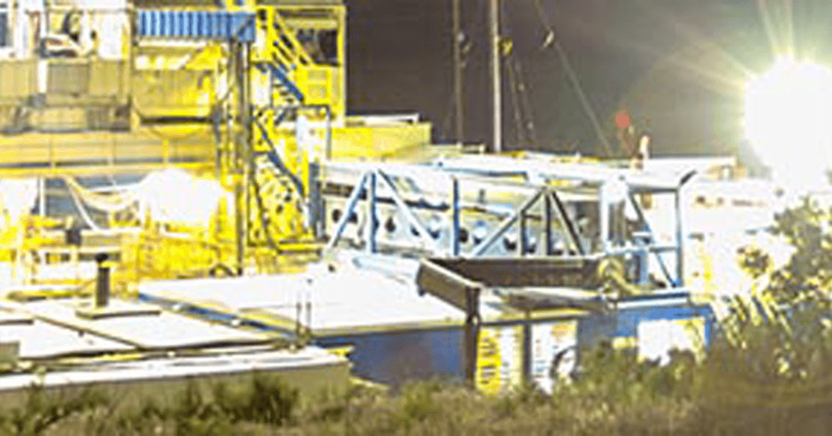 Oil rig and platform at night with lights on.