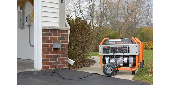 Generac portable generator on sidewalk near garage outside of home.